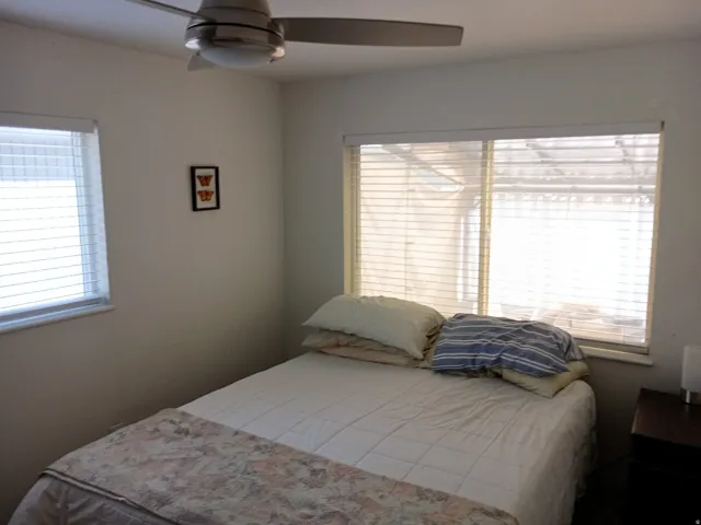 Room featuring multiple windows, a ceiling fan with integrated lighting, and neutral wall tones