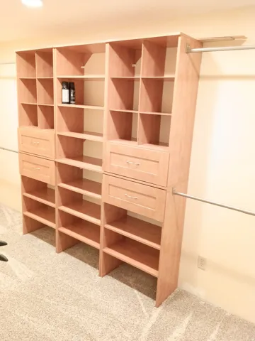 Built-in closet organization system with integrated drawers, shelving, and hanging rods