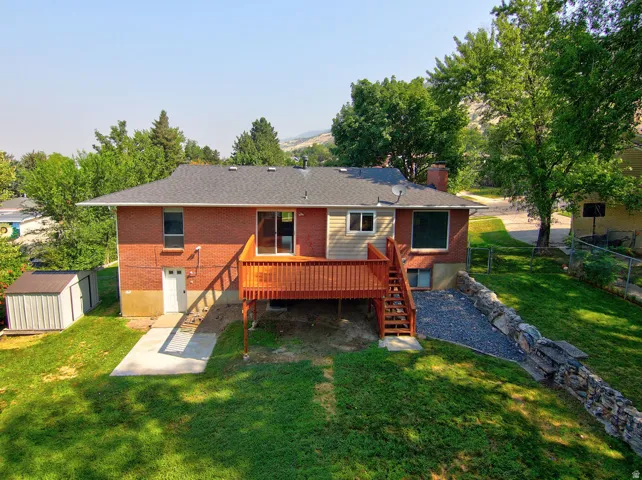 Red brick exterior with siding accents, offering a rear deck with stairs to grade