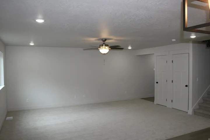 Recessed lighting, ceiling fan light fixture, window with white trim, built-in closet with panel doors, and carpeted flooring