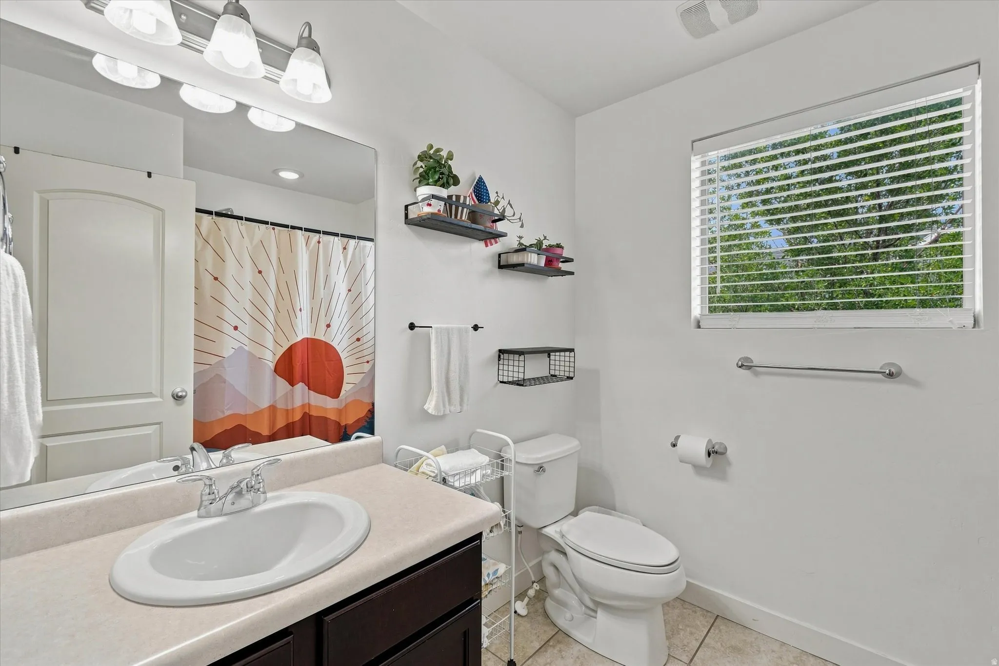 Single vanity with an integrated sink, polished chrome faucet, and expansive wall mirror