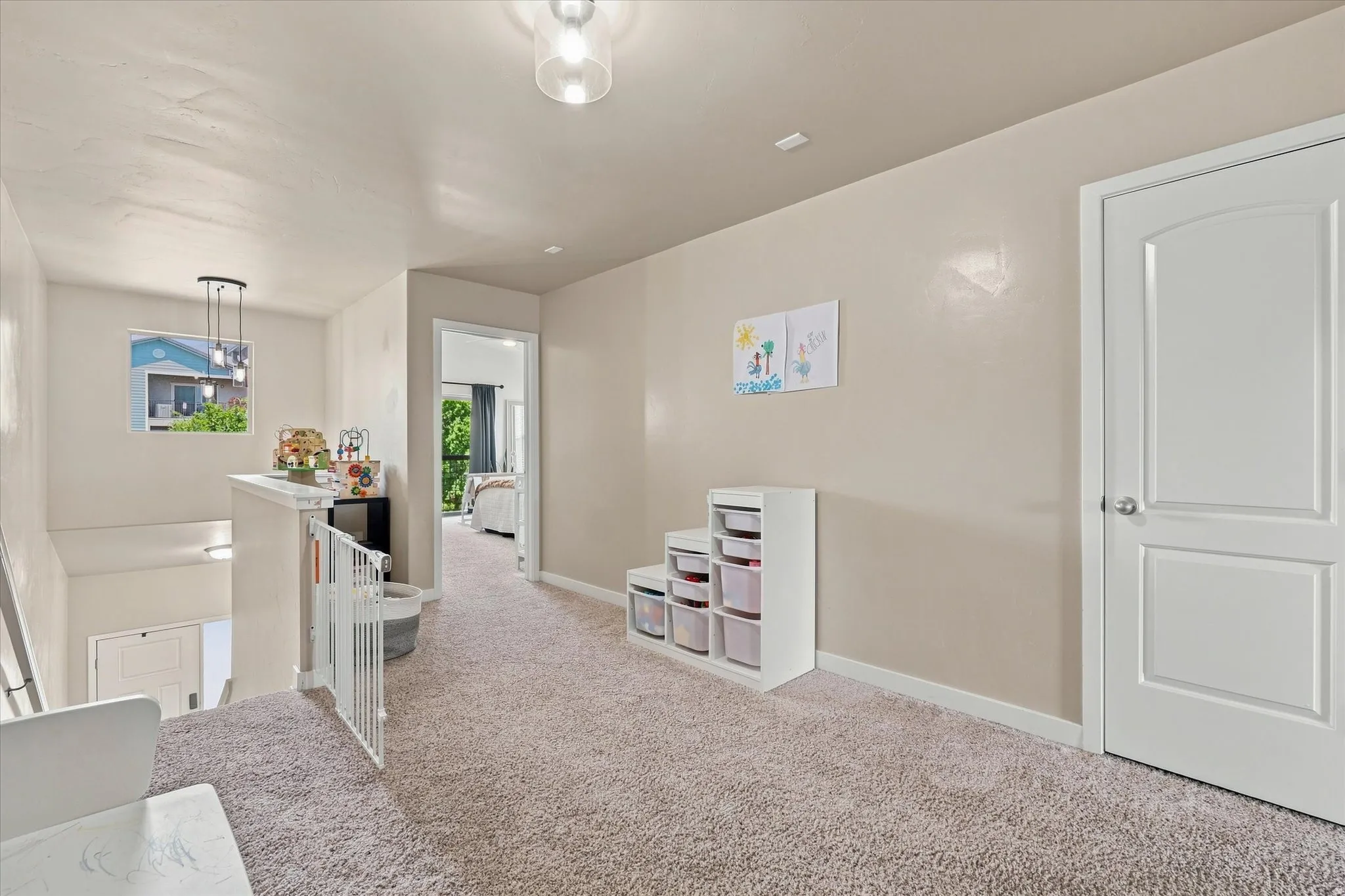 Carpeted landing with a window, contemporary pendant light fixture, and white doors