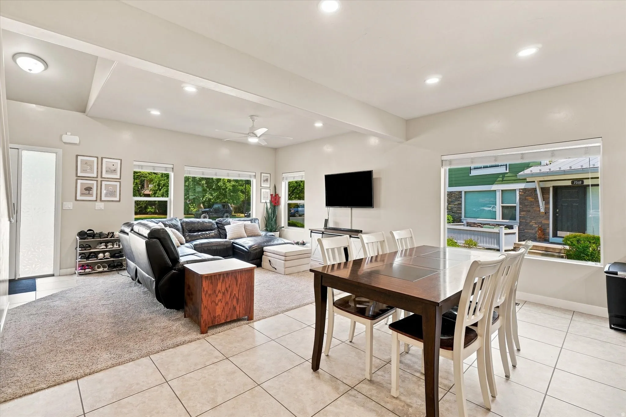 Open-concept living area with vaulted ceilings, recessed lighting, and multiple windows