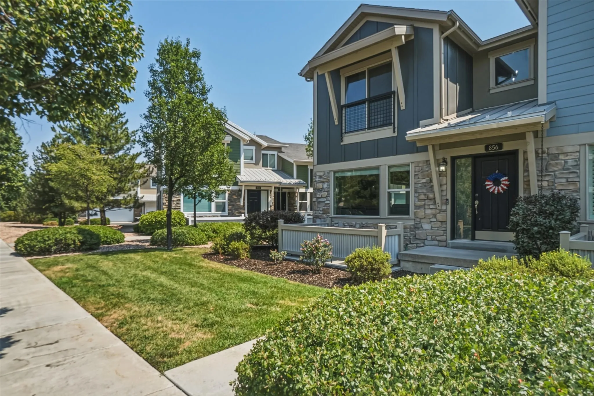 Modern exterior architecture with stone accents, covered entry, and large windows