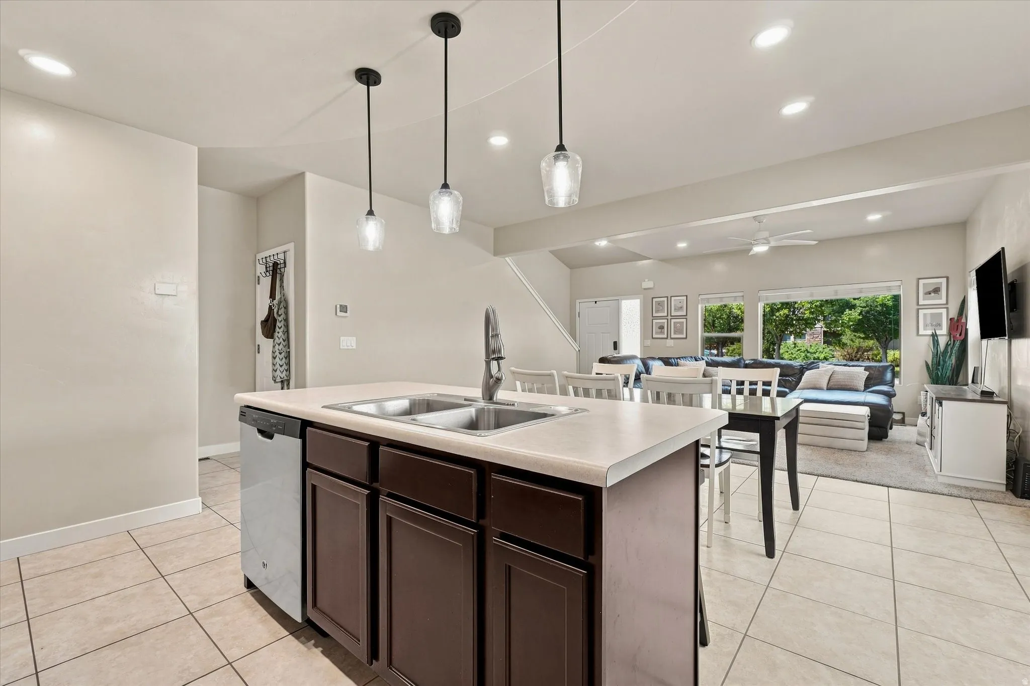 Kitchen island with dual basin sink, integrated dishwasher, and pendant lighting