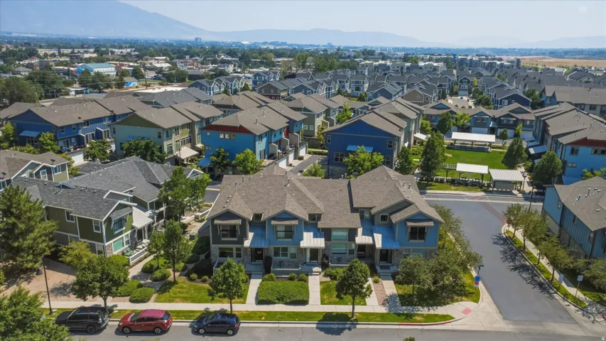 Community featuring multi-level residences, manicured green spaces, and a mountainous backdrop