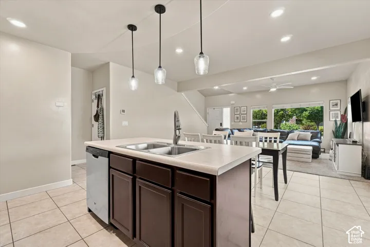 Kitchen island with dual basin sink, integrated dishwasher, and pendant lighting