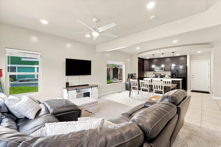 Open-concept living space featuring recessed lighting, a ceiling fan, and multiple windows