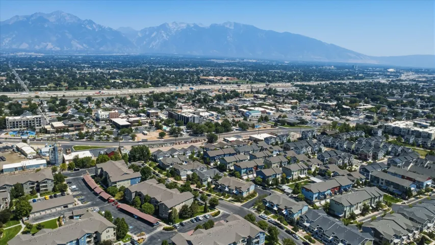 Expansive urban landscape with extensive residential development, commercial districts, and a prominent mountain range backdrop