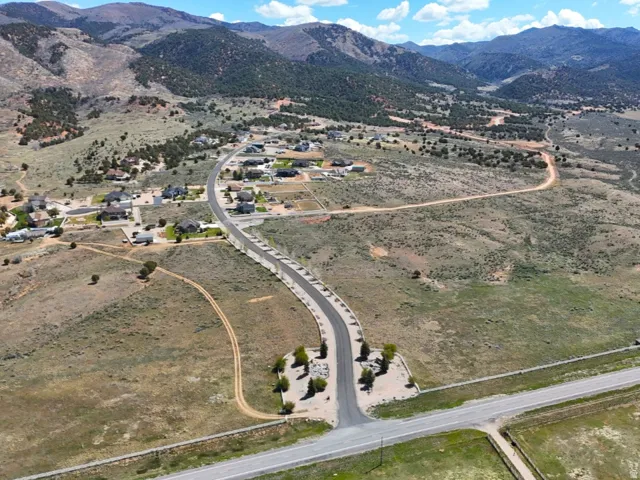 Developing community featuring paved roads, scattered residences, and surrounding natural landscape with distant mountains