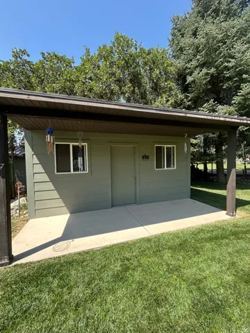 Shed structure with horizontal siding, two windows, and a solid door