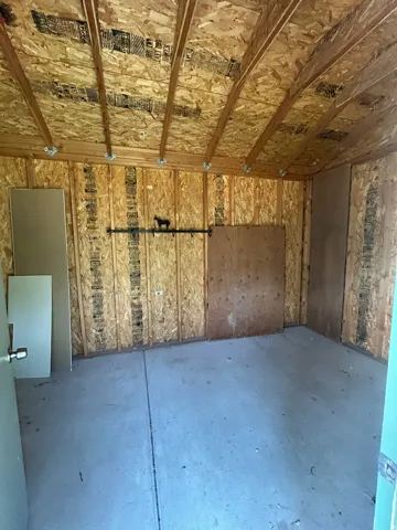 Unfinished interior space featuring exposed wood framing and concrete flooring
