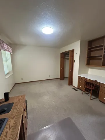 Recessed lighting, wood-finish built-in desk, wood-finish cabinetry, and built-in shelving