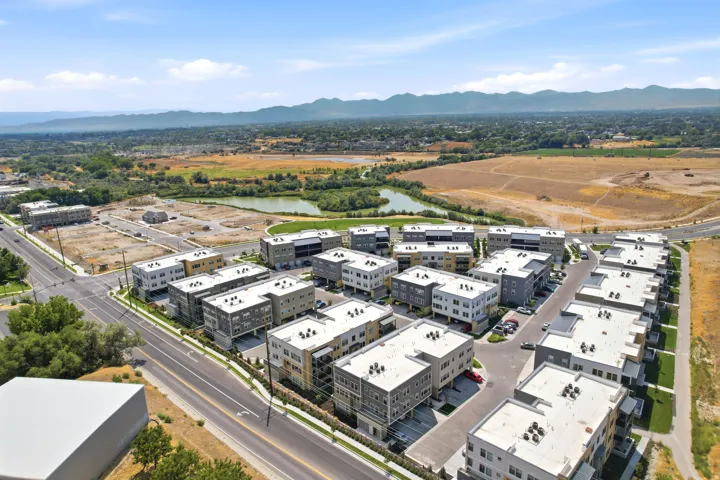 Modern multi-story residential buildings with balconies, situated along paved roadways