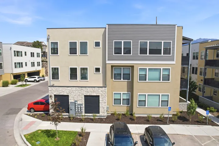Multi-level contemporary exterior with varied siding, stone veneer accents, and multiple windows
