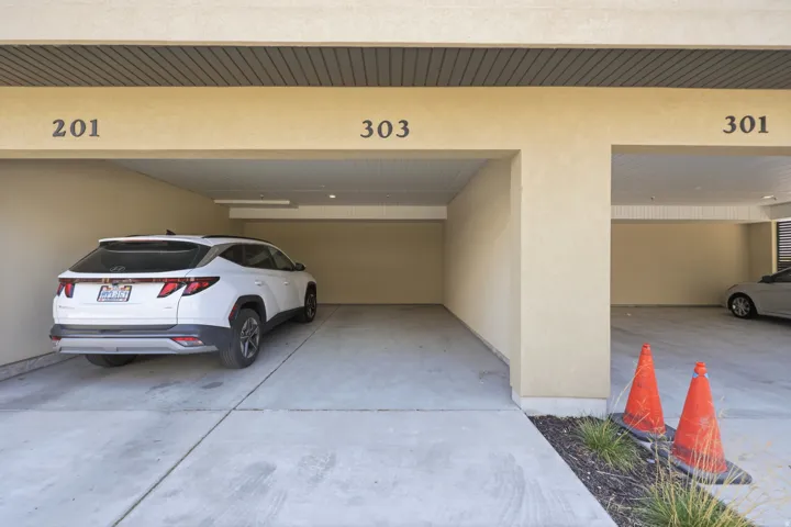 Covered parking space with a concrete surface and stucco walls