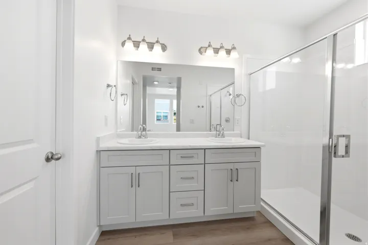 Dual vanity with grey cabinetry, white countertop, and integrated sinks