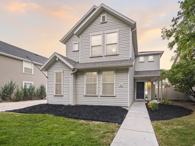 Two-story home with light-colored siding, a covered entry, and a dark front door
