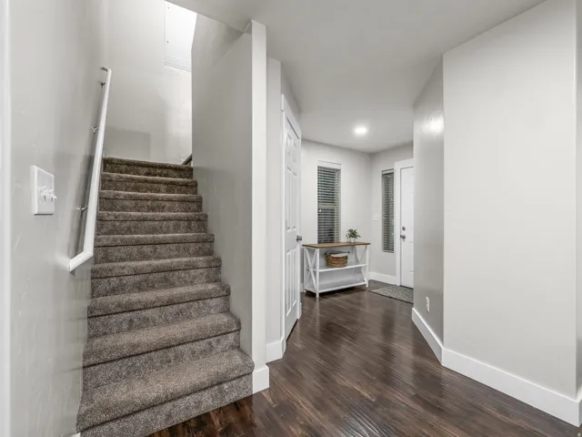 Carpeted staircase with white handrail