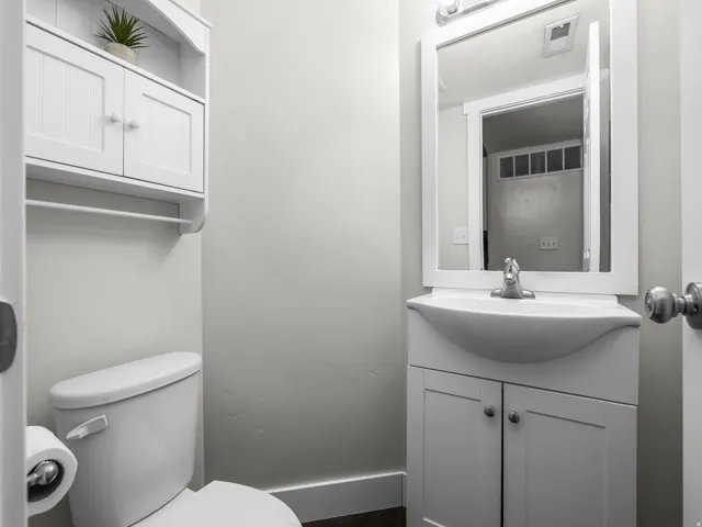 White vanity with integrated sink, framed mirror, and chrome faucet