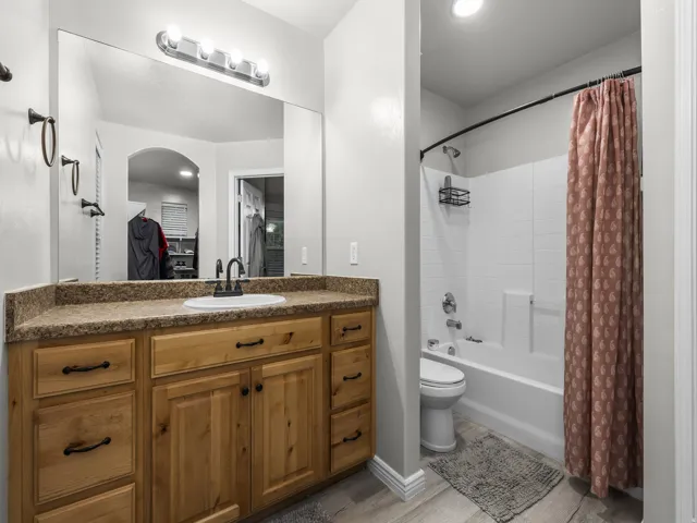 Wood-finish vanity with a surface-mount sink and dark bronze faucet