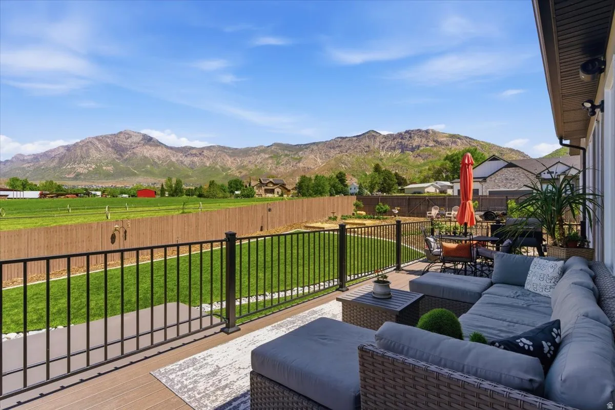 Expansive outdoor deck with black metal railings, composite decking, and a mountain backdrop