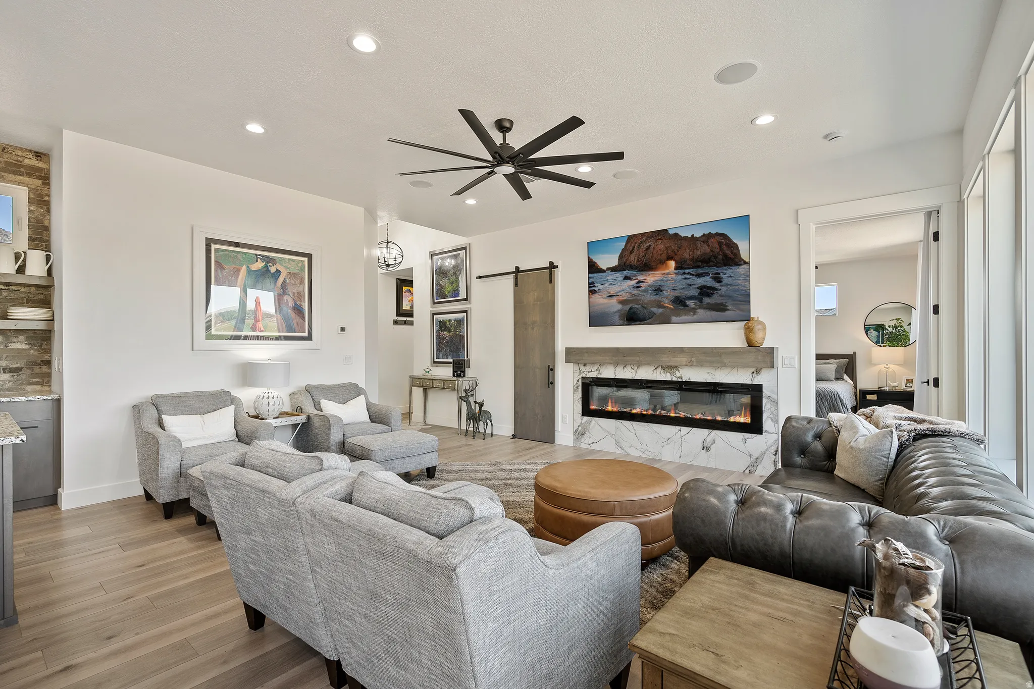 Open-concept living space featuring wood-finish flooring, a contemporary ceiling fan, and recessed lighting