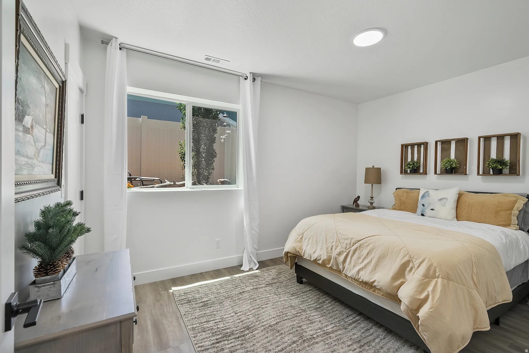 Recessed ceiling lighting, large window, wood-finish flooring, white walls, and dark window trim