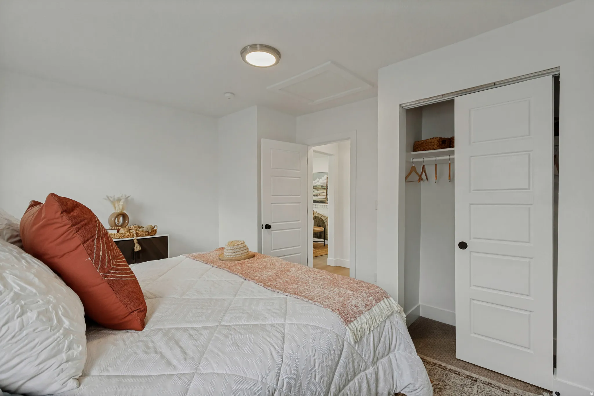 Recessed ceiling light, white paneled doors, sliding closet door, and carpeted flooring