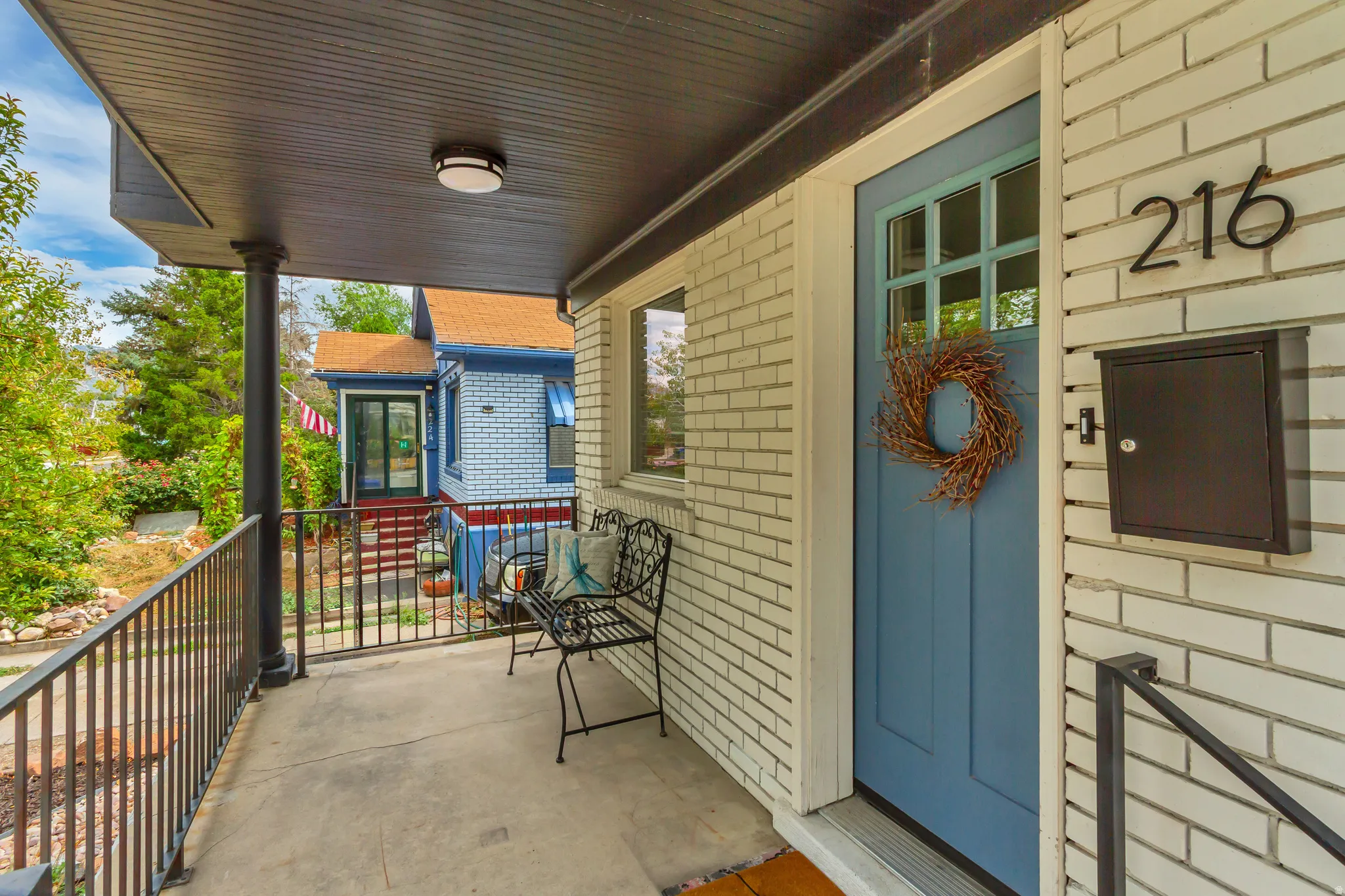Covered porch with concrete flooring and dark metal railings