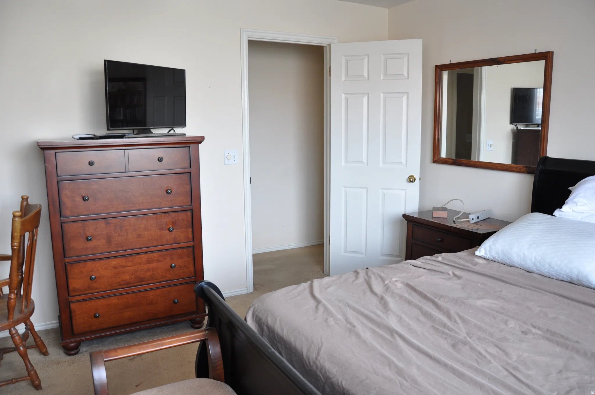 Carpeted flooring, neutral wall paint, and a paneled interior door