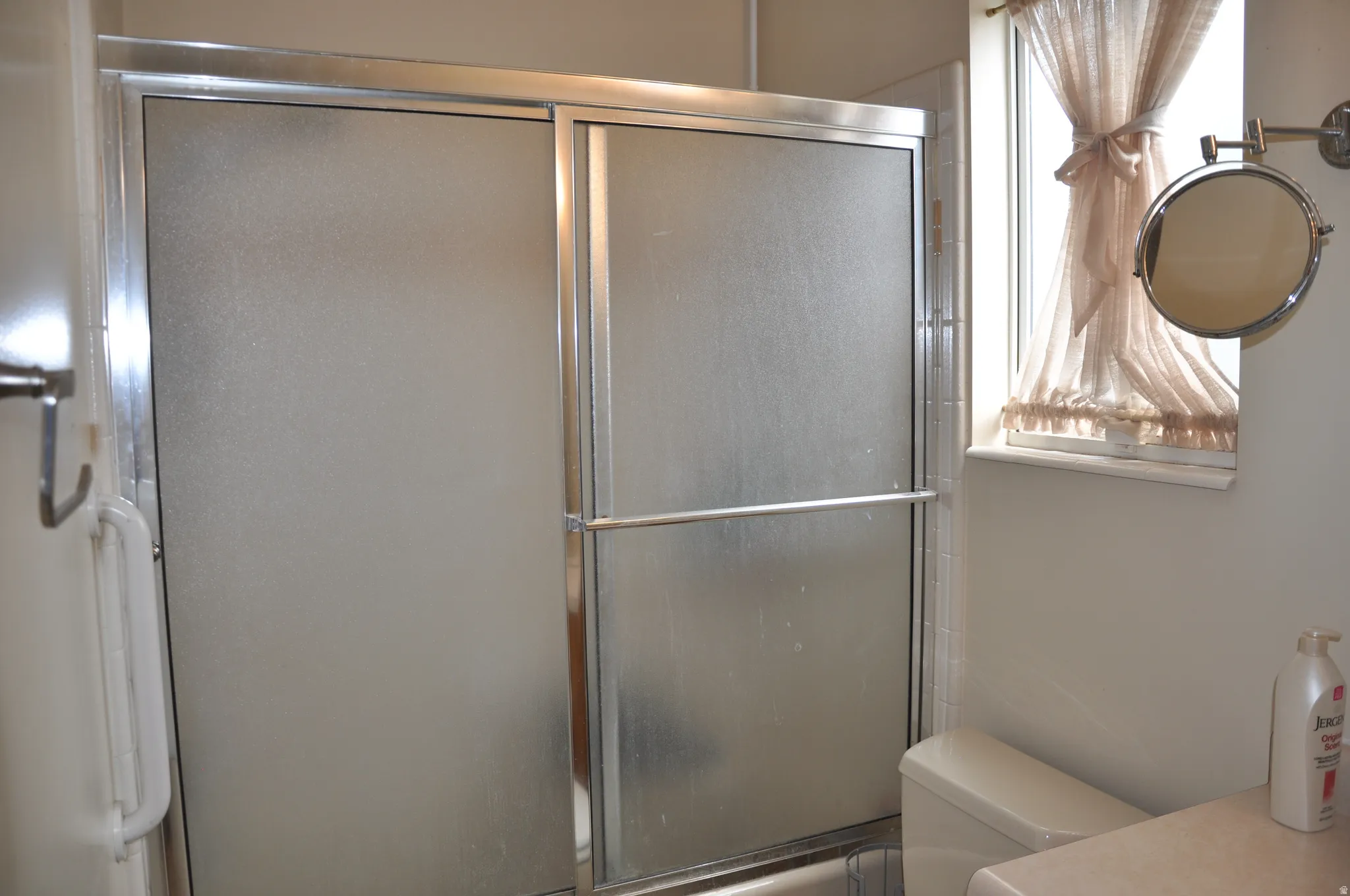 Sliding glass shower enclosure with a chrome frame
