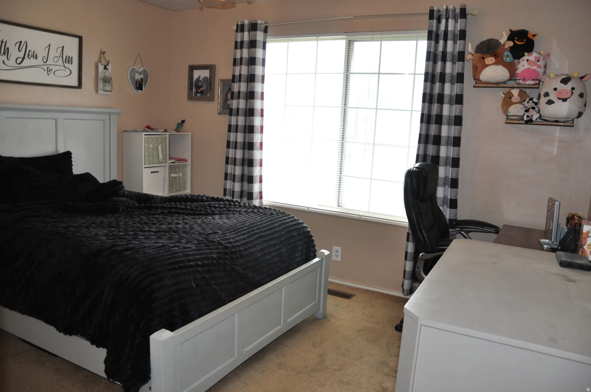 Expansive window with blinds and buffalo check curtains, ceiling fan, and built-in shelving unit