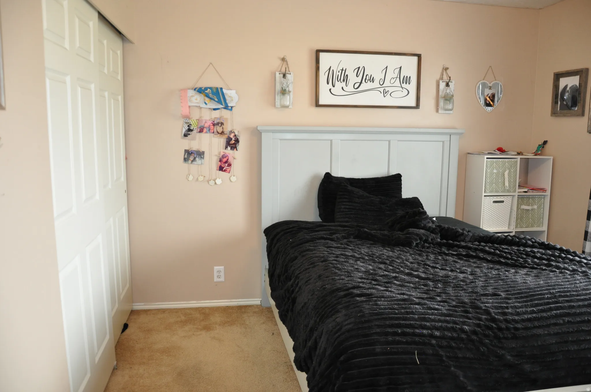 White sliding closet doors, neutral wall paint, and carpeted flooring