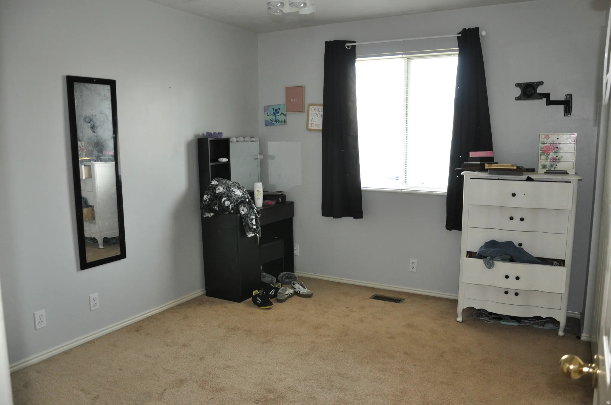 Neutral wall paint, carpeted flooring, and a single window with blinds