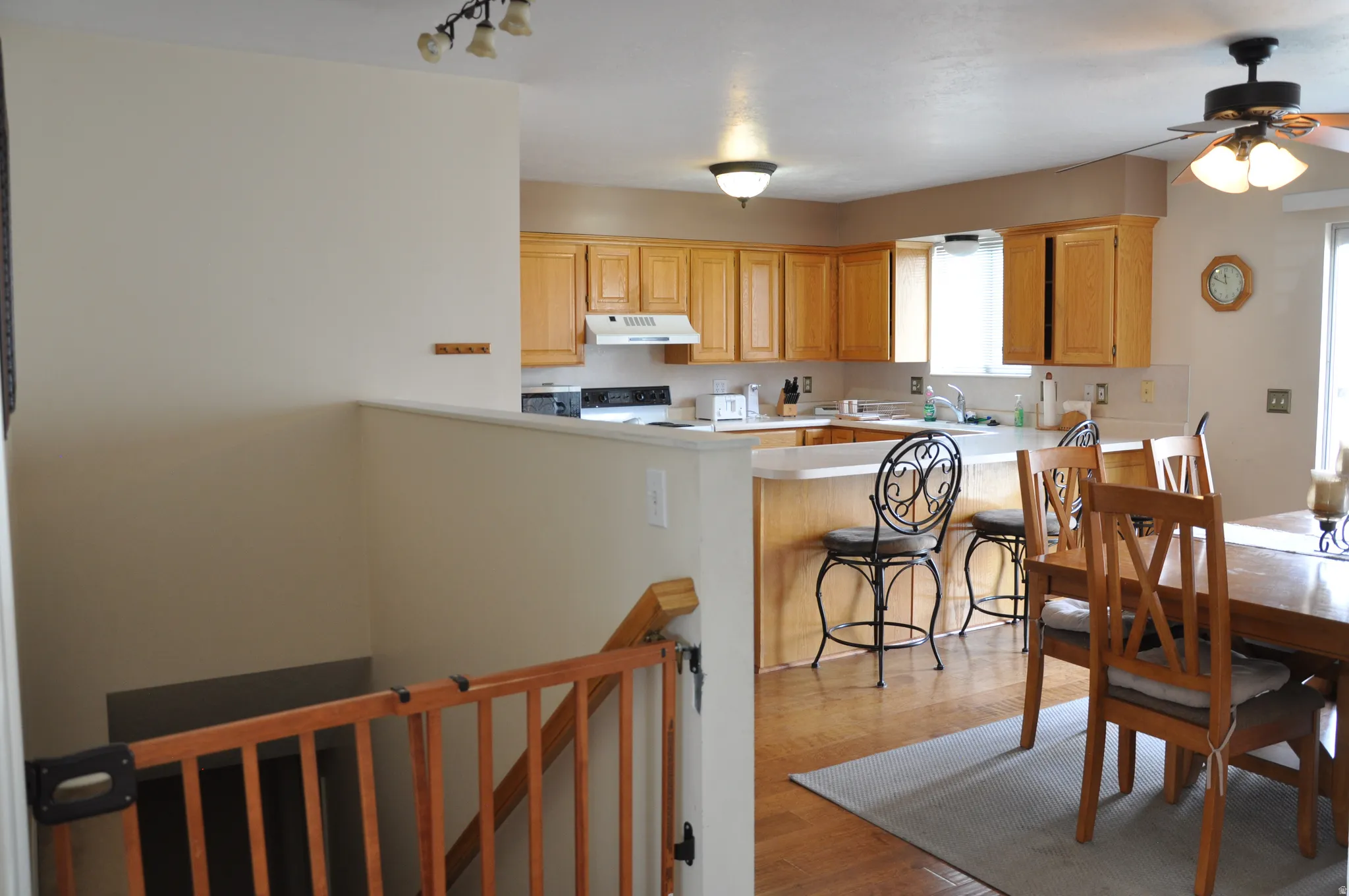 Kitchen featuring wood-finish cabinetry, a white appliance package, and a breakfast bar