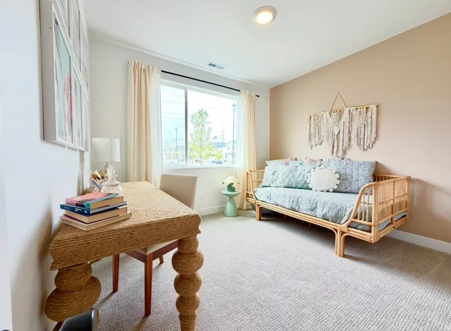 Recessed ceiling lighting, large window with roller shades, carpeted flooring, and light-toned wall finishes