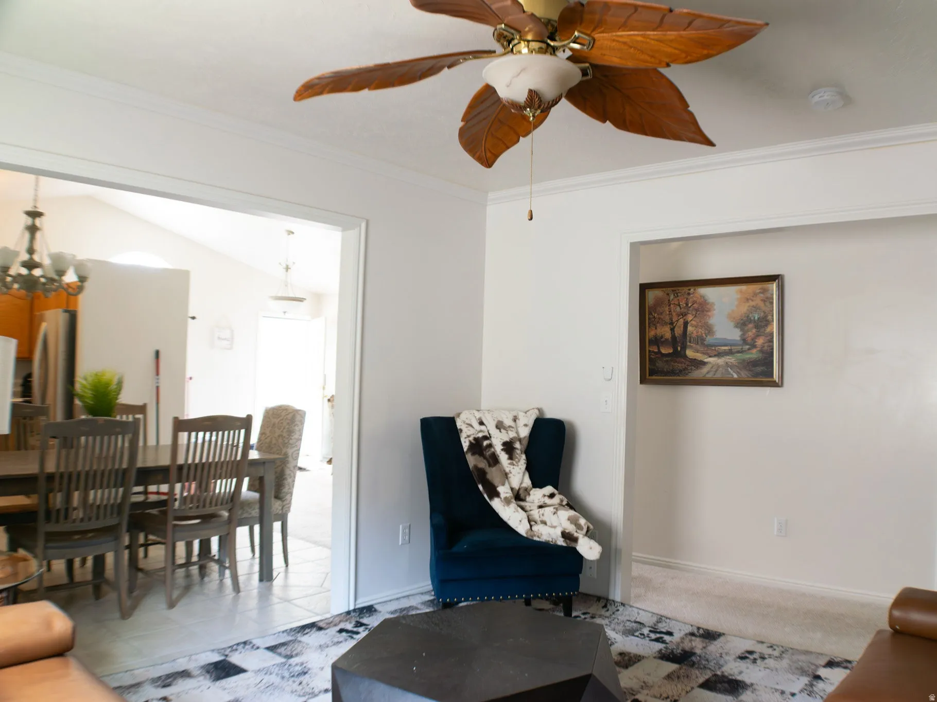 Crown molding, ceiling fan with wood-finish blades, and white trim throughout