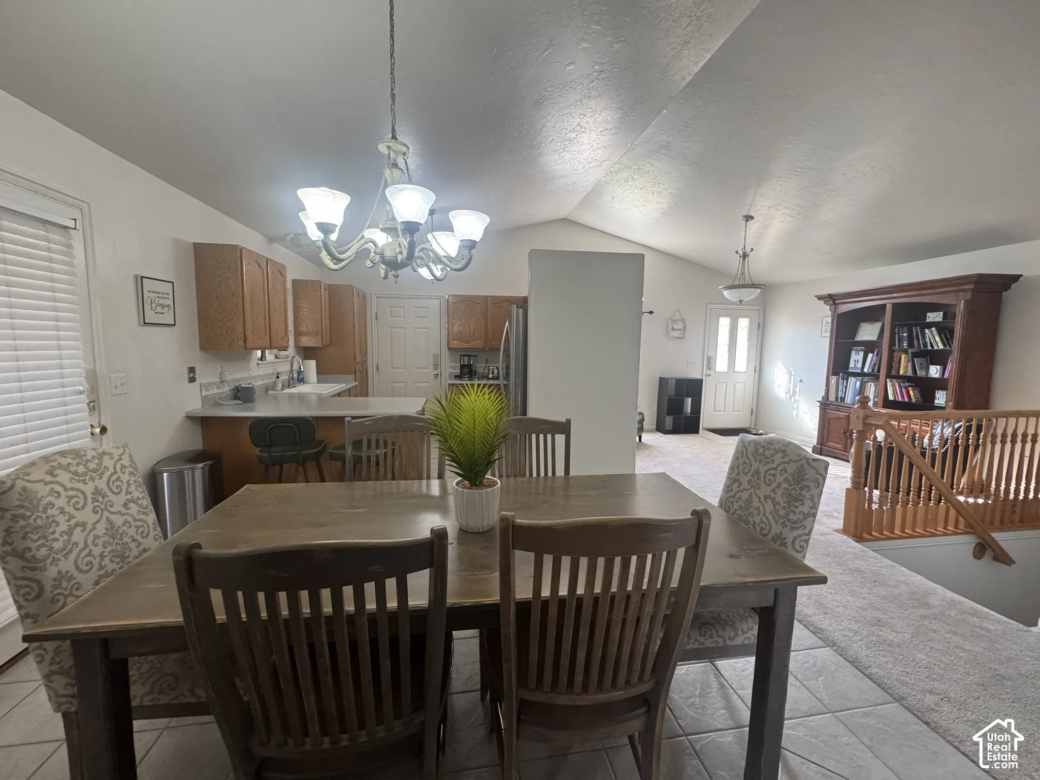 Vaulted ceilings with a five-light chandelier, wood-finish cabinetry, and tile flooring.  All lightbulbs recently replace with bright daylight bulbs to brighten the atmosphere.