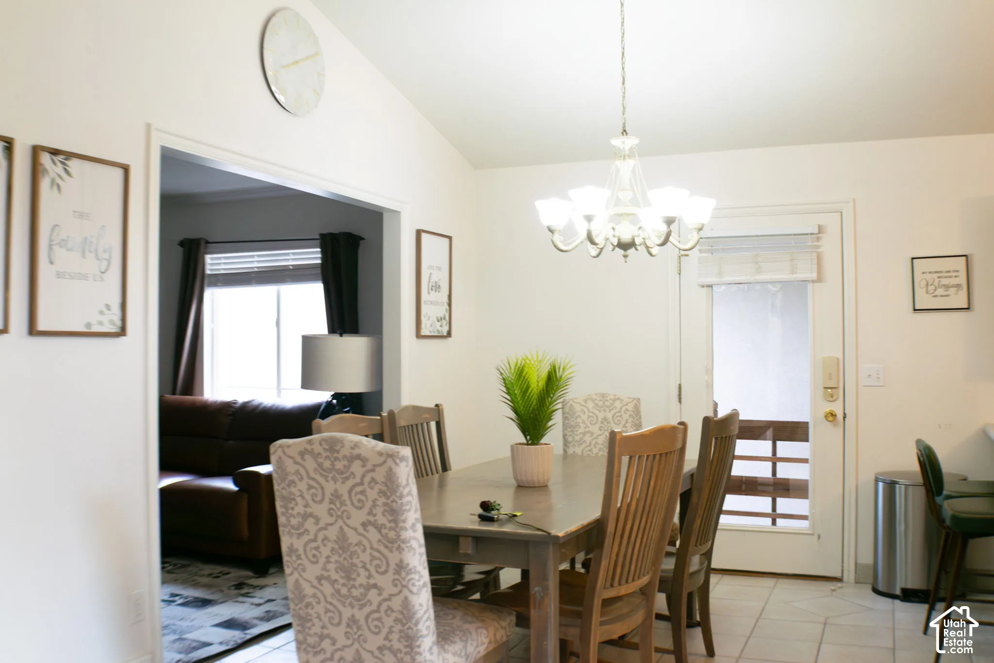 Vaulted ceilings with a chandelier light fixture above the dining area which also has a breakfast bar and provides convenient access to the outdoor patio space.