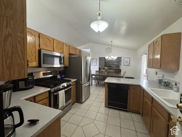 Coming in from the garage entrance, you enter the kitchen featuring wood cabinetry, stainless steel appliances, white countertops, and tile flooring.