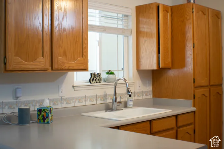 With a view to the patio above the sink this kitchen also features light wood-finish cabinetry, light countertops, and a decorative tile backsplash.  There is also a built in pantry right inside the garage for extensive storage space.