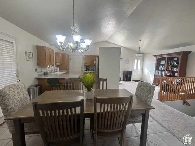 Vaulted ceilings with a five-light chandelier, wood-finish cabinetry, and tile flooring.  All lightbulbs recently replace with bright daylight bulbs to brighten the atmosphere.