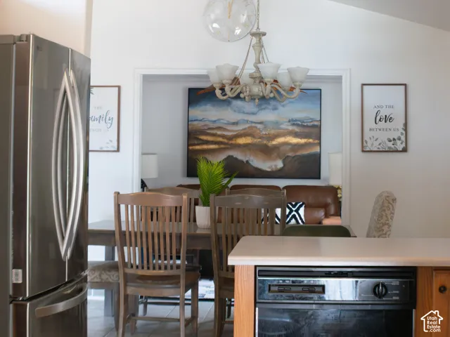 Vaulted ceiling, stainless steel refrigerator, tile flooring, light wood-finish cabinetry, built-in dishwasher