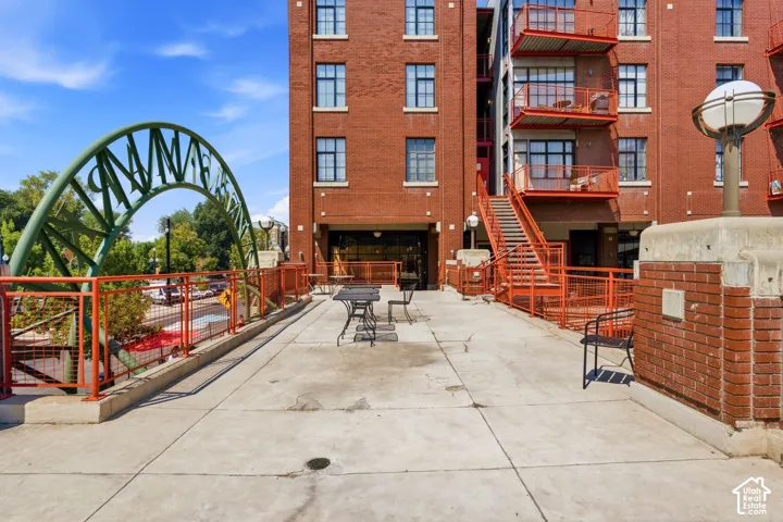 Red brick exterior with multiple floor levels, featuring exterior staircases and balconies