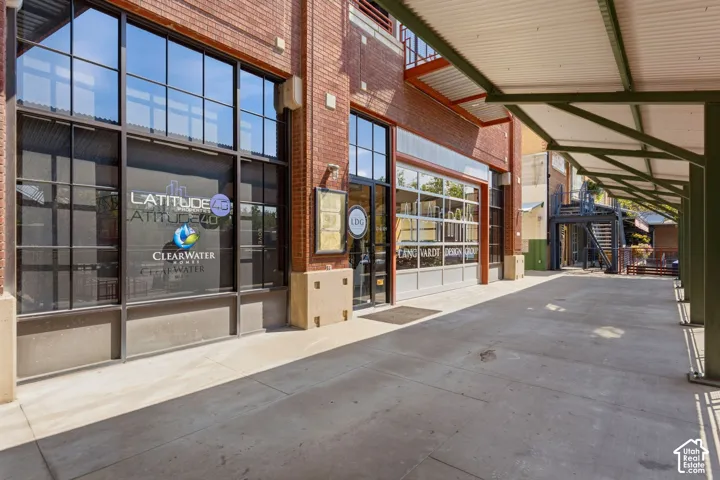 Brick exterior with large storefront windows and a corrugated metal awning
