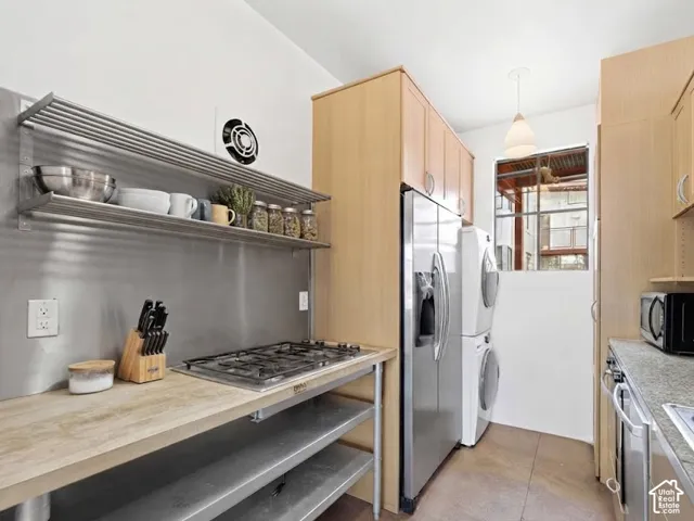 Galley kitchen featuring wood-finish cabinetry, stainless steel appliances, and a gas cooktop