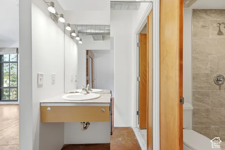 Dual vanity with an integrated sink, track lighting, and a partial mirror