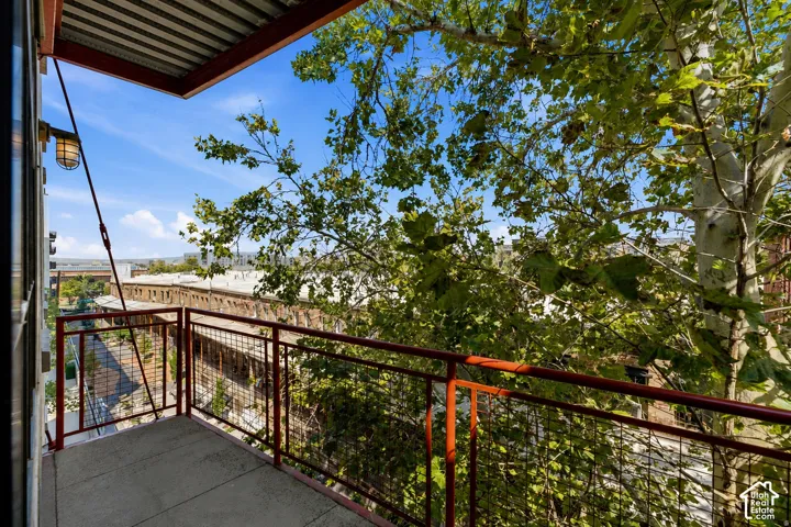 Private balcony featuring a concrete floor, metal railing, and exposed corrugated metal ceiling