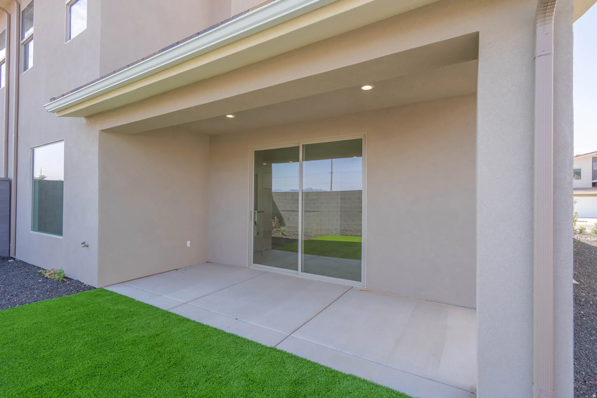 Covered patio with recessed lighting, concrete flooring, and sliding glass door